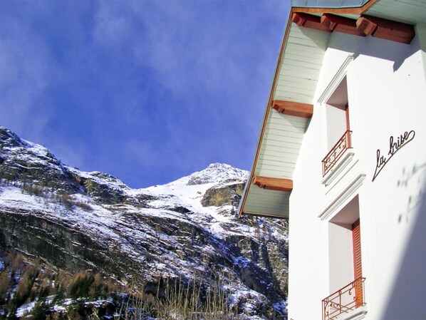 A building with a balcony and a mountain in the background.