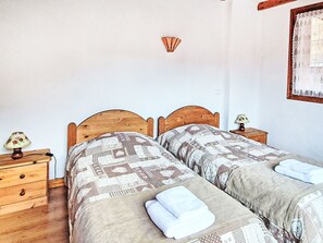 A room with two wooden beds, a nightstand with a lamp, and a wall-mounted light fixture. - Chalet de la Cote by Interhome (Champagny-en-Vanoise)