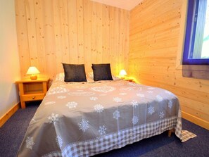 A bedroom with a bed, two bedside tables, and a window. - Chalet Carella by Interhome (Champagny-en-Vanoise)