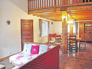 Ein Zimmer mit einem Bett, Holzboden, Fenster und Tür.