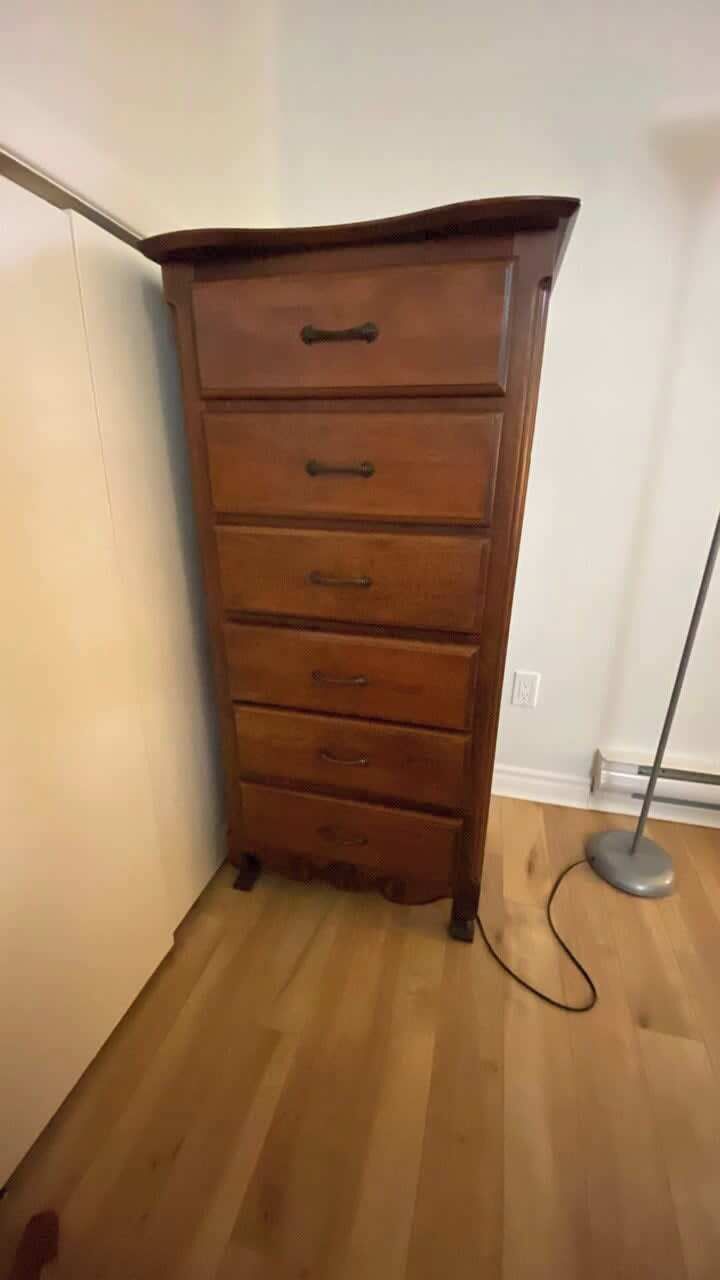 A wooden dresser with drawers and a cable.