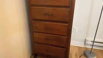 A wooden dresser with drawers and a cable.