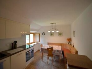 A compact kitchen with a dining area, a sofa, and a small table. - Via Paclera 23, (Sta. Maria - Santa Maria Val Müstair) by Interhome (Sta. Maria GR)