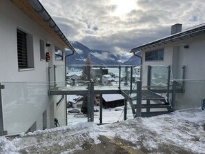 A modern building with a glass balcony overlooking a snowy mountain landscape. - Pellas, Vella, (Vella), 44014B by Interhome (Vella)