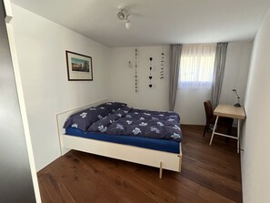 Ein Schlafzimmer mit einem Bett, einem Schreibtisch und einem Stuhl.