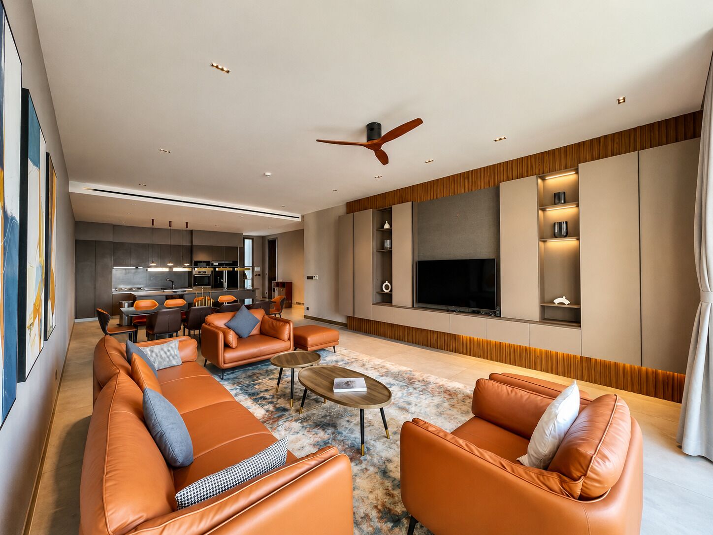 A modern living room with leather sofas, a coffee table, and a TV.