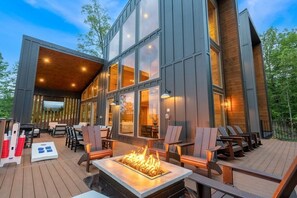 A modern building with a deck area featuring outdoor seating and a fire pit. - Views/HotTub/GameRoom/2FirePits/3Masters/Sleeps10! (Sevierville)