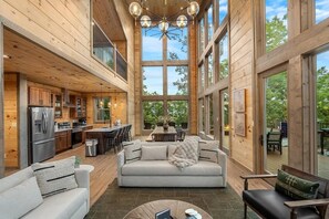 A spacious interior with a kitchen, dining area, and seating space. - Views/HotTub/GameRoom/2FirePits/3Masters/Sleeps10! (Sevierville)