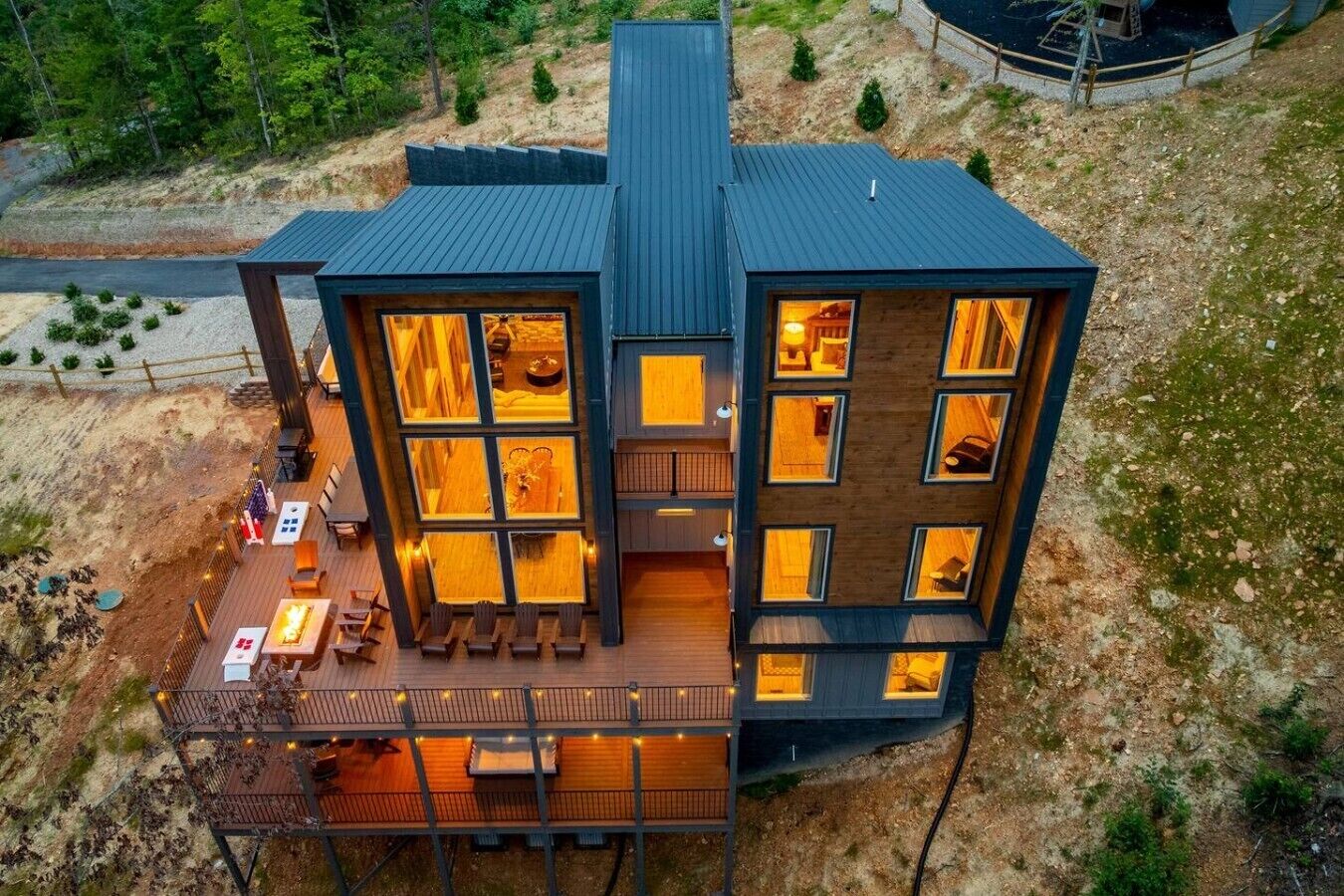 A modern multi-story building with large windows, a deck, and outdoor seating.