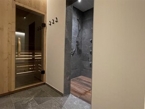 A hallway leading to a bathroom with a shower and a glass door. - mit Terrasse by Interhome (La Villa/Stern)