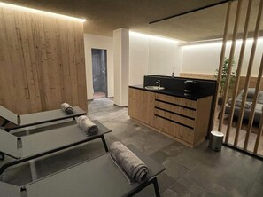 A modern kitchen with wooden cabinets, a black countertop, and a small sink. - mit Terrasse by Interhome (La Villa/Stern)
