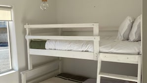 Ein Etagenbett mit drei Schlafstellen, einer Hängeleuchte und einem Fenster mit Blick.