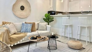 A modern living room with a sofa, coffee table, and a large decorative shell on the wall. - Le Bohémien Signature Apartment in La Marsa (La Marsa)