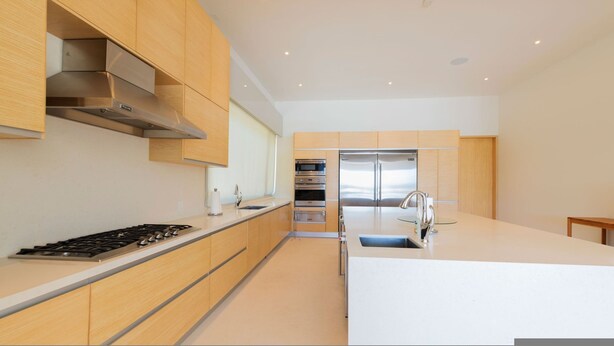 Een moderne keuken met roestvrijstalen apparatuur, houten kastjes en een centraal eiland.