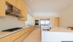 Una cocina moderna con electrodomésticos de acero inoxidable, armarios de madera y una isla central.