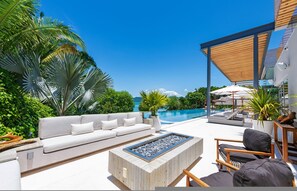 A modern outdoor seating area with a pool, white furniture, and tropical plants. - Casa Brisa 7BD - Kupuri Punta Mita (Punta de Mita)