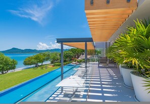 A modern outdoor pool area with a clear view of the ocean and mountains in the background. - Casa Brisa 7BD - Kupuri Punta Mita (Punta de Mita)