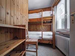 A bunk bed room with wooden walls, a radiator, and a window with a view. - Paradies 046 Appartement/Fewo, Bad, WC, 4-Bettwohnung 4-Bettwohnung by Interhome (Arosa)