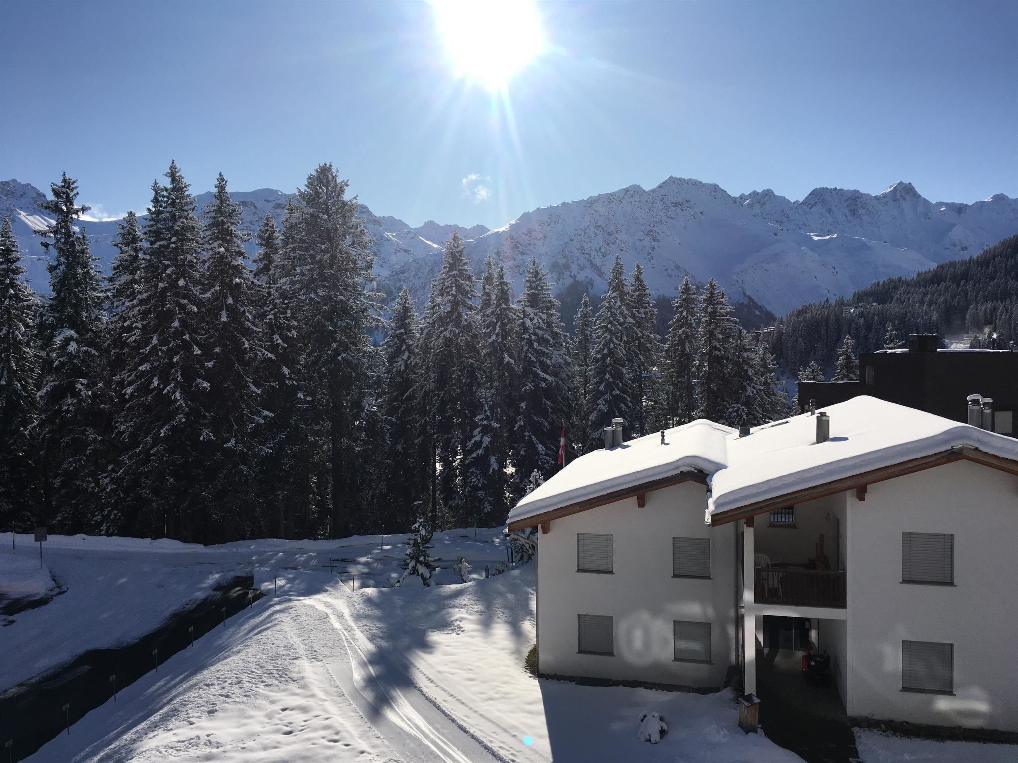 A snow-covered mountain landscape with a building that has a white exterior and a sloped roof.