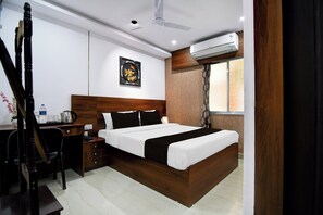 Une chambre d’hôtel équipée d’un lit, d’un bureau, d’une chaise et d’un appareil de climatisation.