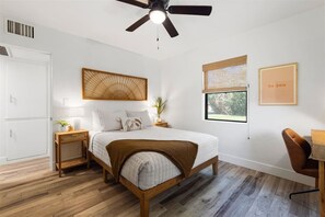 A bedroom with a bed, bedside tables, a ceiling fan, a window with a view, and a wall with a poster. - Hubbell Hideaway House by Downtown Phoenix (Phoenix)