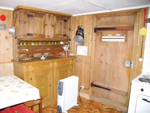 Una cucina compatta con mobili in legno, un fornello e un termosifone.