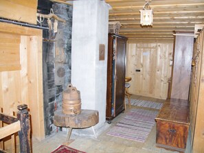 A wooden interior with a stone wall, a wooden cabinet, and a rustic wooden stool. - Ferienhaus Altes Walserhaus, Brün, (Valendas-Brün), 22004B by Interhome (Valendas)