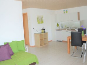 Un appartement moderne comprenant un salon, une cuisine et un espace repas.