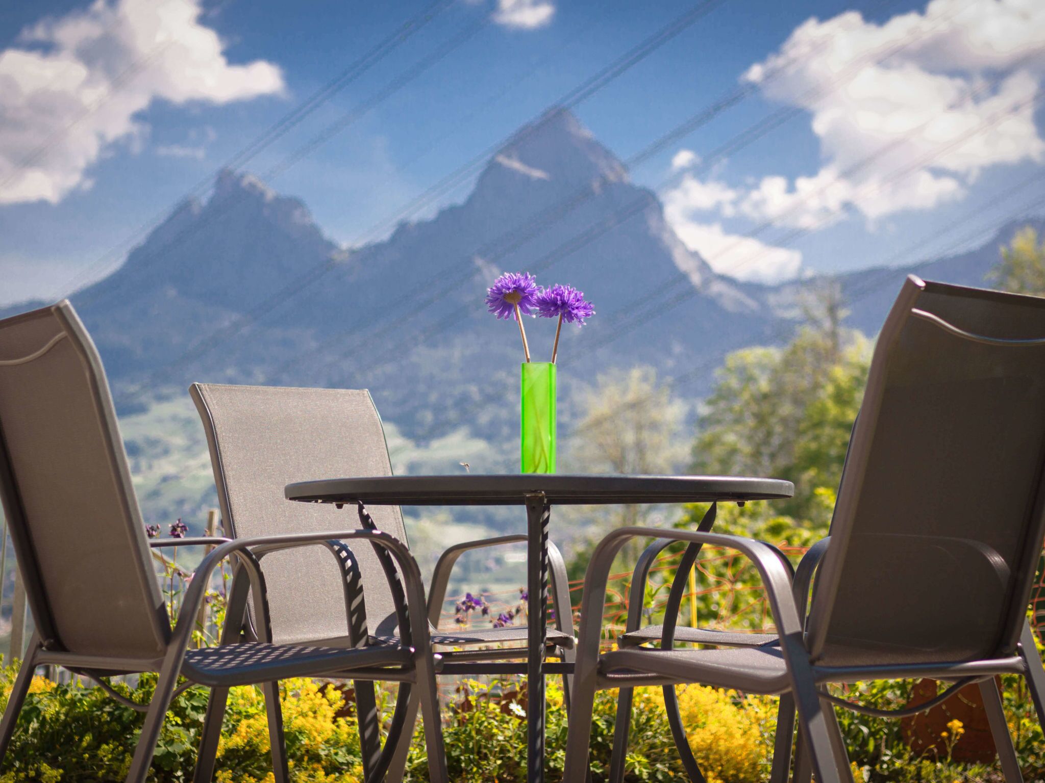 Mesa com duas cadeiras voltada para uma vista de montanha.
