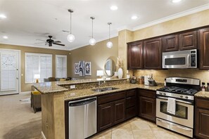 A modern kitchen with granite countertops, stainless steel appliances, and dark wood cabinets. - Grayhawk Townhome in Northern Scottsdale (Scottsdale)