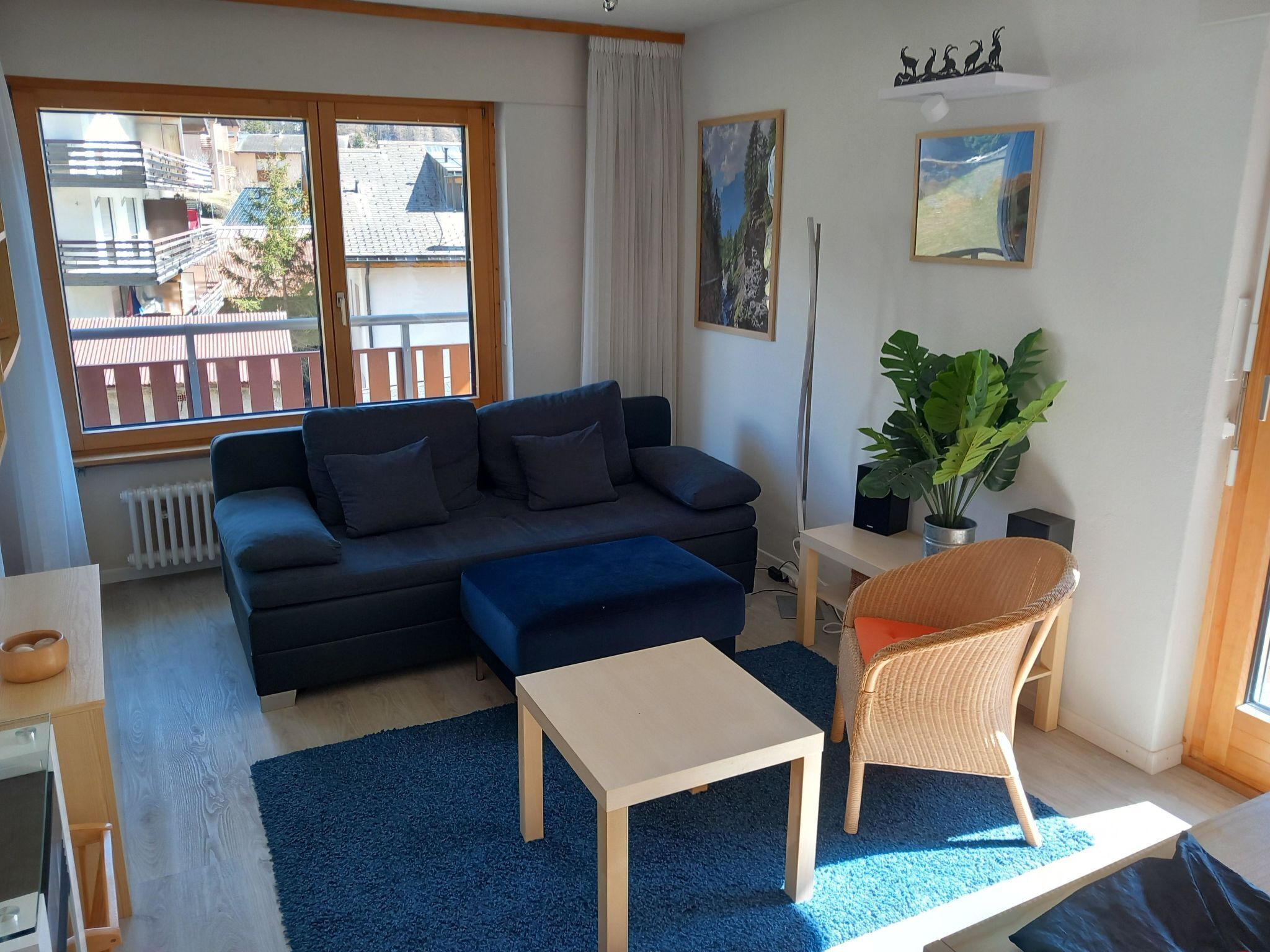 Un salon moderne avec un canapé, une petite table, un fauteuil et une plante en pot.