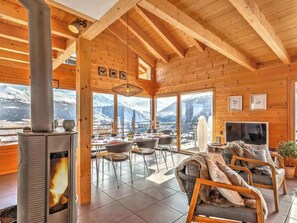 Ein rustikales Interieur mit Kamin, Essbereich und Sitzgelegenheiten.