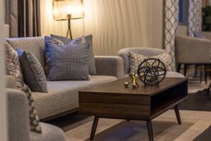 A modern living room with a sofa, a coffee table, and decorative items. - Troon: Scottsdale Condo, Views & Heated Pool (Scottsdale)