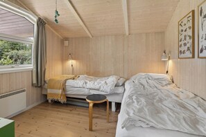 A room with two beds, a window with curtains, a wall-mounted lamp, and framed pictures. - Holiday home near the water on scenic Møn (Askeby)