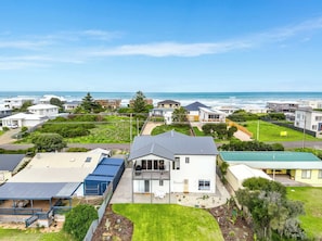 A residential area with houses, a grassy yard, and a view of the ocean. - Beachside Family Escape 92 Newell Avenue Middleton Spacious 4-Bedroom Holiday Home Sleeps 10 one street from Middleton Beach (Middleton)