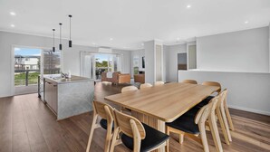 Un interno moderno con zona pranzo, cucina e vista sull'esterno.
