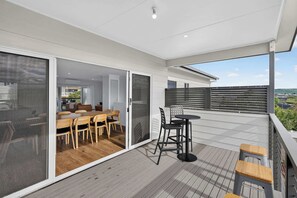 Eine moderne Außenpatio mit Essbereich, einem kleinen Tisch und Stühlen sowie Blick auf die Stadtlandschaft.