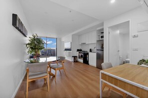 Ein modernes Apartment mit Essbereich, Küche und einem Balkon mit Blick.