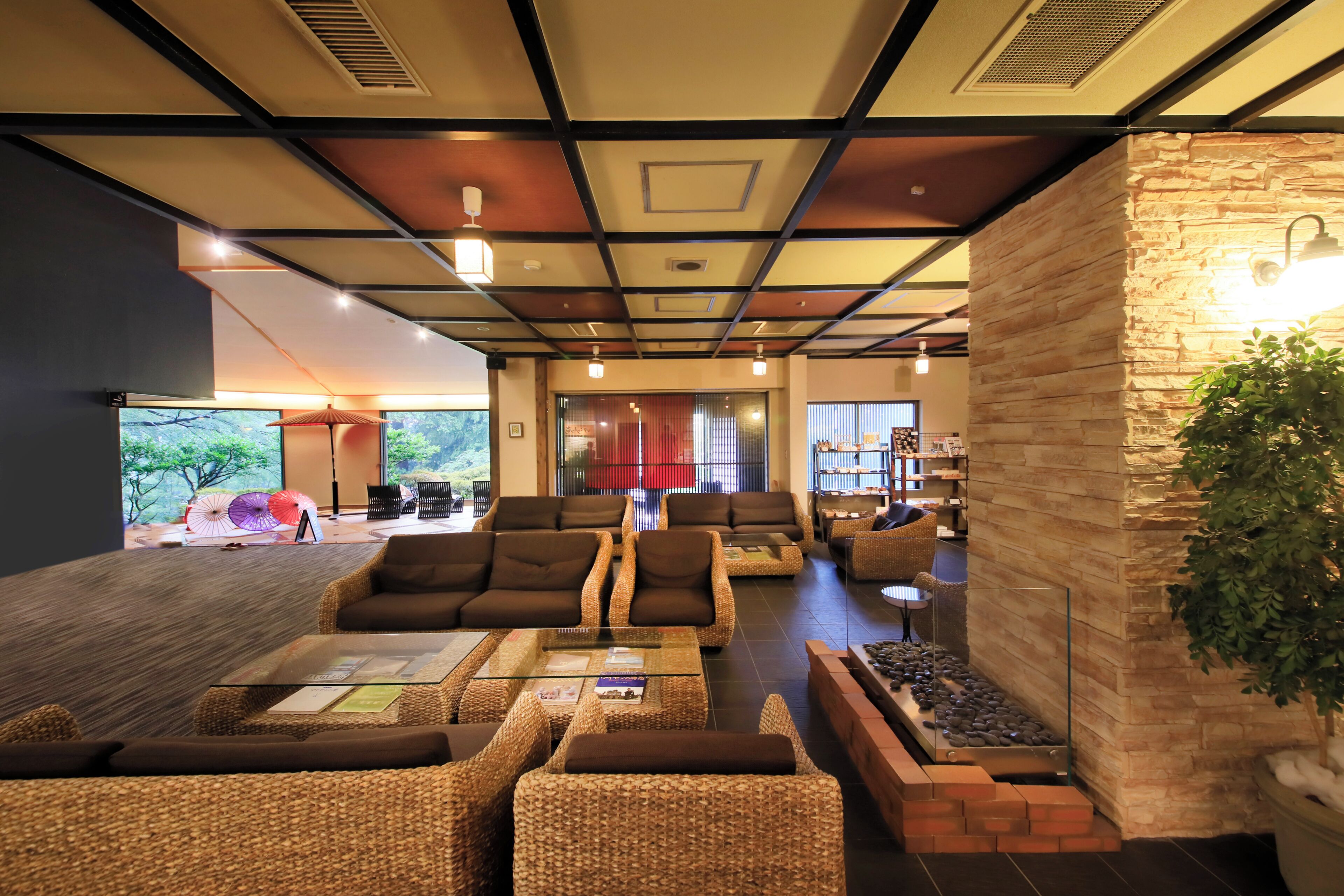 Un vestíbulo moderno con muebles de mimbre, una pared de acento de piedra y vistas al exterior.