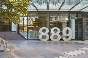 Een moderne gevel met grote glazen deuren en het nummer 889 duidelijk zichtbaar.