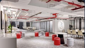 Un espace de bureau moderne avec des murs blancs, des touches de rouge et différents types de mobilier, notamment des tables et des chaises.