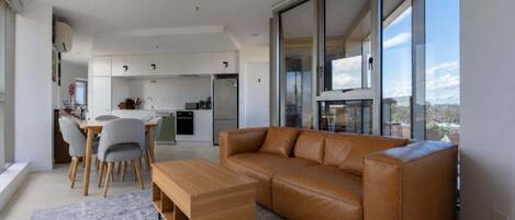 A modern living room with a leather sofa, a wooden coffee table, and a patterned rug.