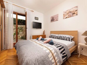 Un dormitorio con cama, televisión y vistas al exterior.
