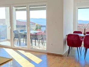 A room with a sliding glass door leading to an outdoor area with a table and chairs. - Apartment Basilea - 03 by Interhome (Krk/Milohnići)