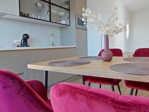 A modern kitchen with a built-in microwave, a coffee machine, and a vase with white flowers on the counter. - Apartment Basilea - 03 by Interhome (Krk/Milohnići)