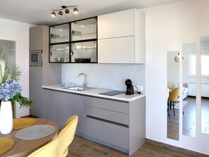 Eine moderne Küche mit eingebauter Mikrowelle, einem Spülbecken und einer Kaffeemaschine.