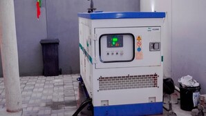 Een draagbare industriële machine met een digitaal display, buiten op een verhard oppervlak geplaatst.
