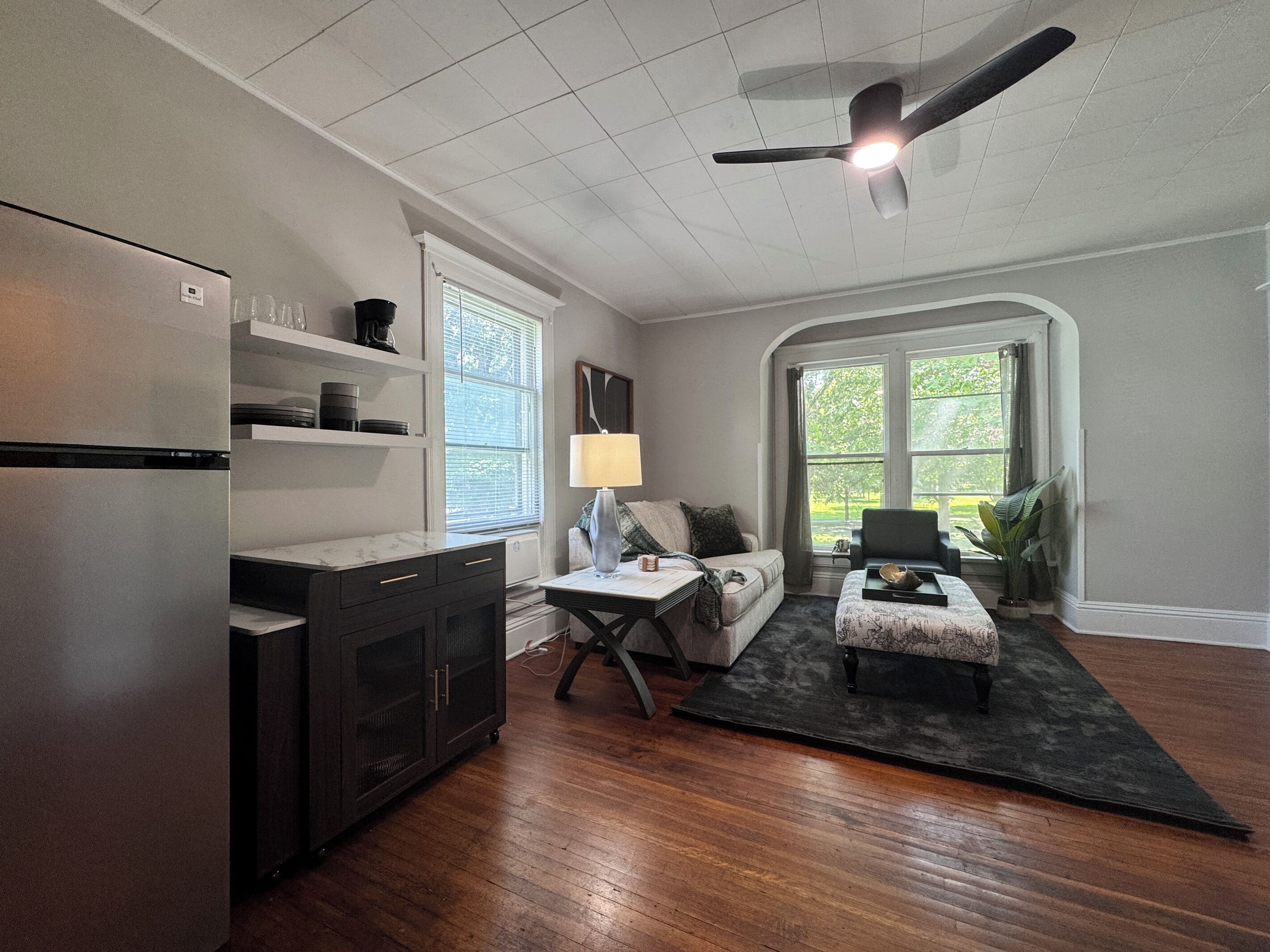 A modern kitchen with a built-in refrigerator, a dining area with a table and chairs, and a large window providing natural light.