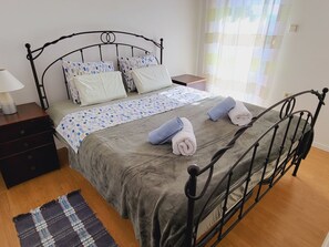 A neatly made bed with a grey duvet, two rolled towels, and patterned pillows. - Apartment Italo - 2 by Interhome (Krk/Njivice)