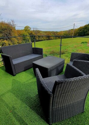 A set of outdoor wicker furniture on artificial grass.